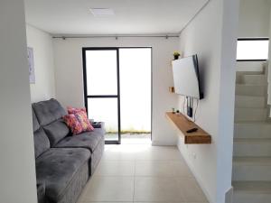 a living room with a couch and a tv at Perto da praia espaço amplo terraço, churrasqueira in Pontal do Paraná