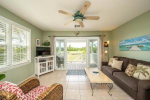 Una sala de estar con un sofá y un ventilador de techo. en Golf Villa, en Key West