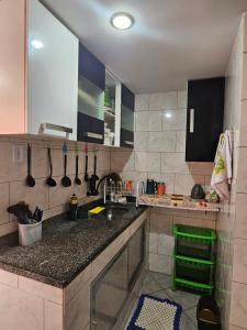 a kitchen with a sink and a counter with utensils at Ibicuí Beach house in Mangaratiba
