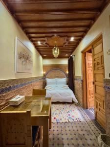 ein Schlafzimmer mit einem Bett, einem Schreibtisch und einem Tisch in der Unterkunft Riad Asswar in Rabat