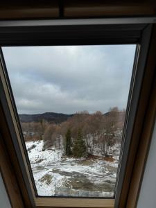 una ventana con vistas a un campo cubierto de nieve en Apartment Meri in Kraljevi Cardaci, en Kopaonik