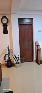 Cette chambre dispose d'une porte en bois et d'une horloge murale. dans l'établissement Migela Restaurant & Rooms, à Walliwala East