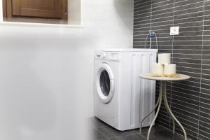 a washing machine in a bathroom with a table at San Massimo Apartment - Piazza Duomo L'Aquila in LʼAquila