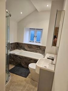 a bathroom with a tub and a toilet and a sink at Rural Escape and Dog Friendly in Nether Stowey +23 photos
