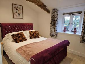 a bed with a red headboard in a bedroom at Rural Escape and Dog Friendly in Nether Stowey