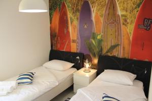 two beds in a room with surfboards on the wall at Apartments Villa Vera in Tivat