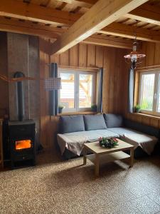 a living room with a couch and a wood stove at Chata Kopaninská pastvina in Rohozná