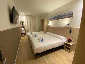 a hotel room with two beds and a television at Hostal BESTPRICE Barcelona Stadium in Barcelona +37 photos