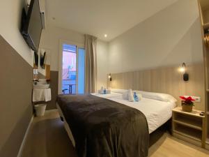 巴塞罗那Hostal BESTPRICE Barcelona Stadium的有一张大床和一扇窗户的酒店房间