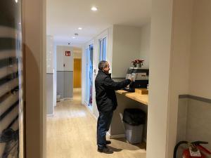 a man standing at a desk in an office at Hostal BESTPRICE Barcelona Stadium in Barcelona