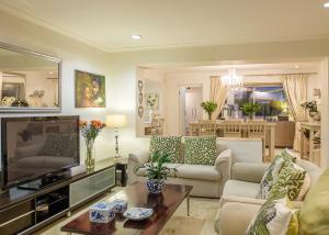 a living room with a couch and a tv at TarongaVilla in Constantia