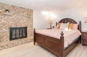 a bedroom with a bed and a brick fireplace at 2 bedroom apartment-2 free parking -14 min to Pearson airport in Mississauga
