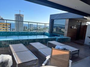 uma piscina com vista para a cidade em Studio moderno e charmoso no melhor lugar da Barra em Salvador
