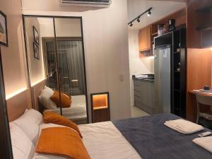um pequeno quarto com uma cama e uma cozinha em Studio moderno e charmoso no melhor lugar da Barra em Salvador mais 72 fotografias