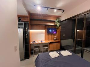 um quarto com uma cama, uma escrivaninha e uma televisão em Studio moderno e charmoso no melhor lugar da Barra em Salvador