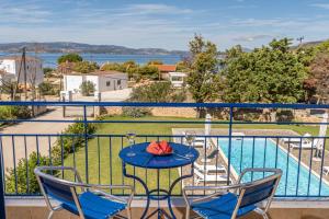 a balcony with a table and chairs and a pool at Eglina Celeste Villa in Minia