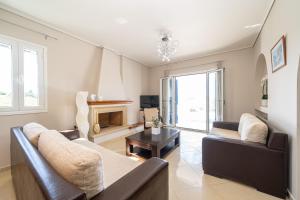 a living room with two couches and a fireplace at Eglina Celeste Villa in Minia