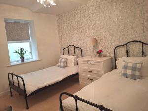 two twin beds in a bedroom with a window at Fenkle Street Alnwick Apartment in Alnwick