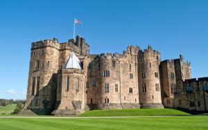 a castle with a flag on top of it at Fenkle Street Alnwick Apartment in Alnwick