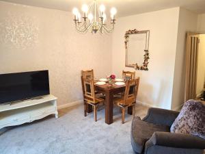 a living room with a table and chairs and a television at Fenkle Street Alnwick Apartment in Alnwick