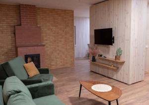 a living room with a couch and a fireplace at GobeHouse Sodyba in Vilkanastrai
