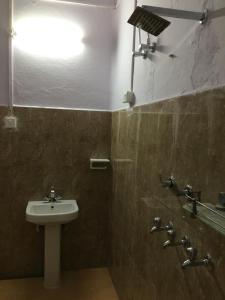 a bathroom with a sink and a light on the wall at Sangam Homestay in Prayagraj