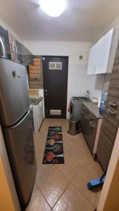 a kitchen with a refrigerator and some food on the floor at Acogedora Casa en Talca 3 dormitorios para 8 personas céntrica in Talca