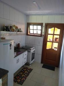 a small kitchen with a stove and a door at Chalé da Rô in Santo Antônio do Pinhal +7 photos