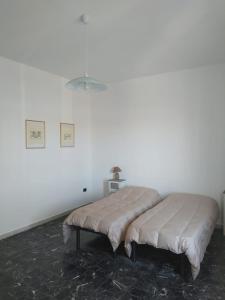 a bed in a room with a white wall at THALASSA Beach Poetto in Cagliari