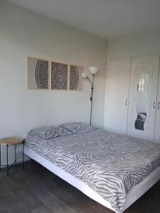 une chambre avec un lit avec des draps à imprimé zèbre dans l'établissement Charmant T3 aux portes de Bordeaux - 2 chambres, à Lormont