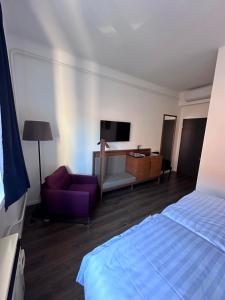 a hotel room with a bed and a couch and a tv at Pécs Centrum Apartman in Pécs
