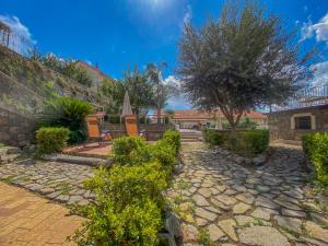 a garden with a stone walkway and a tree at Le Oreadi in Agerola
