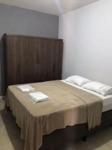 a bedroom with a large bed with towels on it at Hotel El Shaday in Nazário