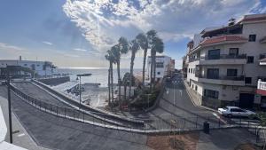 a street with palm trees next to the ocean at Apartment Volcano Beach in Alcalá