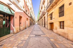 an empty street in an old town with buildings at Canals by Unik Vacation in Tarragona