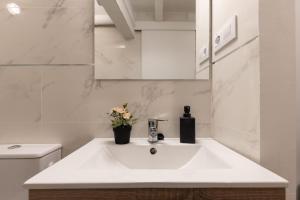 a white bathroom with a sink and a toilet at Canals by Unik Vacation in Tarragona +33 photos