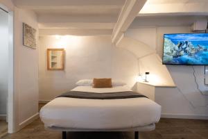 a bedroom with a bed and a tv on the wall at Canals by Unik Vacation in Tarragona