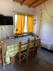 comedor con mesa y cama en Complejo de cabañas en Nono, en Nono