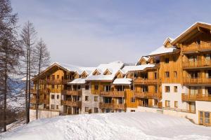 duży budynek apartamentowy ze śniegiem na ziemi w obiekcie CENTRE STATION 1800 - Dernier étage Rénové - 2 Chambres 6 personnes - Skis aux pieds w mieście Les Orres