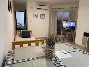 een woonkamer met een bank en een tv bij Departamento Vista Bella, céntrico y cercano a la terminal, Exc ubicación, playa estacionamiento cercana-económica in Villa María