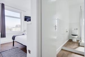 a white bathroom with a bed and a toilet at Azure Beach Hotel in Bournemouth +101 photos