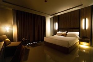 a hotel room with a bed and a chair at Kraal Hotel Vlore in Vlorë