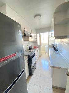 eine Küche mit Kühlschrank und Herd oberen Backofen in der Unterkunft Bello Departamento soleado in Valparaíso