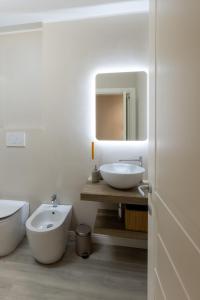 a bathroom with two sinks and a toilet and a mirror at Bianca - Roby - Paolo Apartments by Mamo Florence in Florence