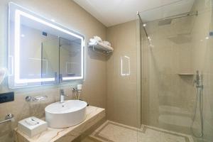 a bathroom with a sink and a shower at Kraal Hotel Vlore in Vlorë