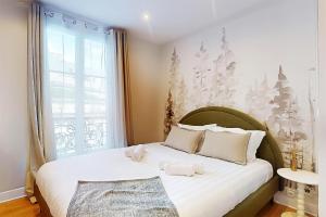 a bedroom with a bed with two stuffed animals on it at F2 Trocadero in Paris
