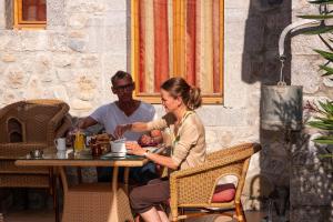a man and a woman sitting at a table at Hôtel La Garenne in Labeaume