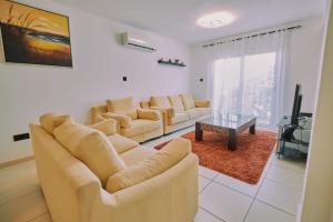 a living room with two couches and a tv at Rosam Seaview Holiday apartment in Ayia Napa