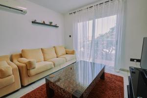 a living room with a couch and a glass table at Rosam Seaview Holiday apartment in Ayia Napa +10 photos