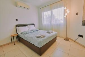 a bedroom with a bed with two towels on it at Rosam Seaview Holiday apartment in Ayia Napa